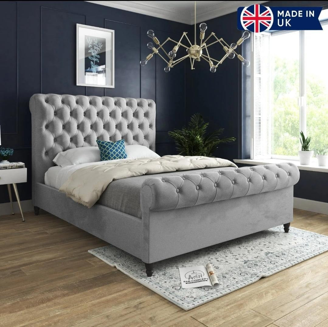 A modern bedroom featuring a stylish upholstered bed frame with a TV elegantly placed at the foot.