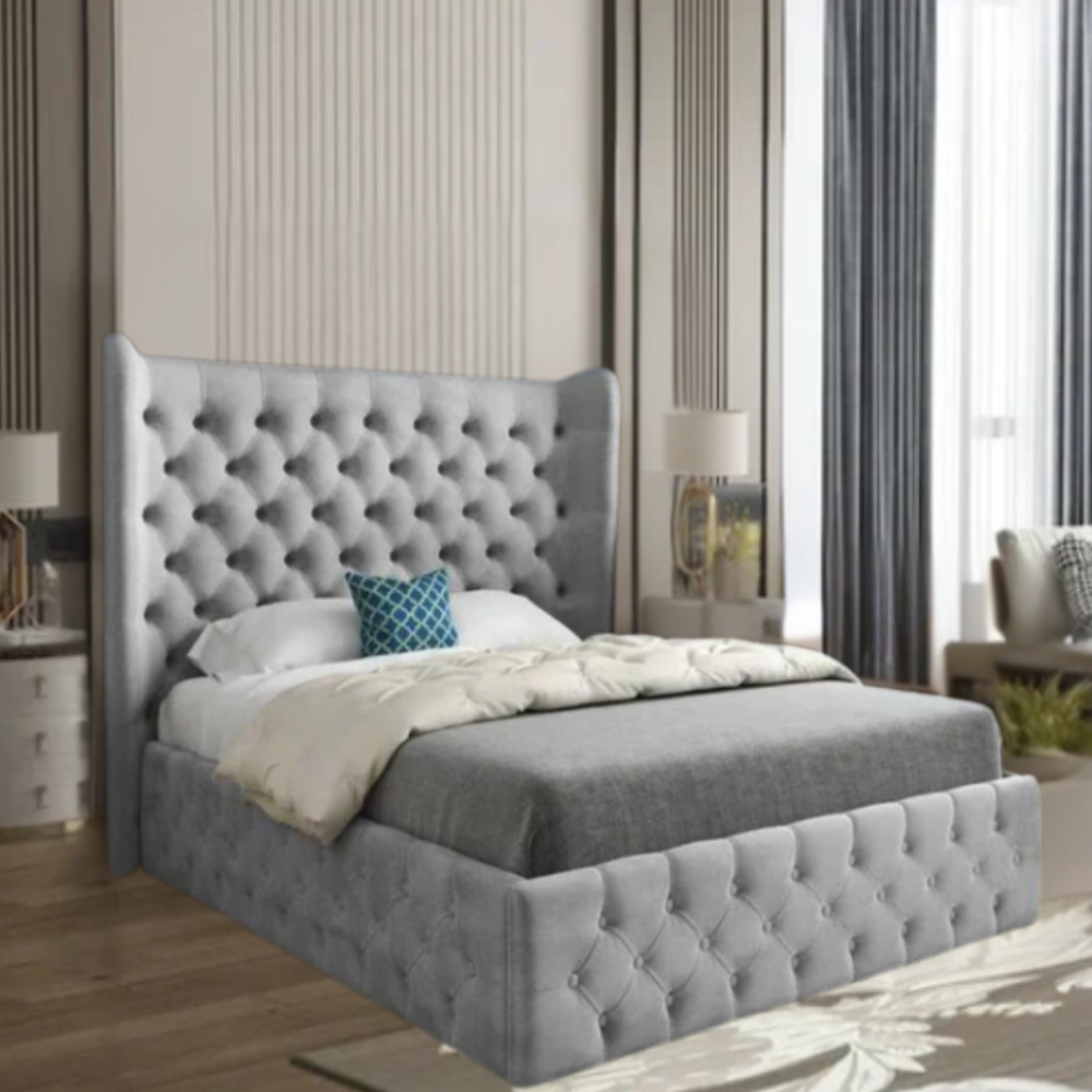 A bedroom with a grey tufted bed, cream duvet, and blue pillow, featuring striped walls and floor-to-ceiling windows with curtains.