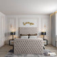 Luxurious bedroom with beige tufted bed, gold leaf art, and elegant decor. 2025 florence tv bed in stylish setting.