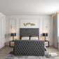 Bedroom with grey tufted 2025 Florence TV bed, white pillows, gold accents, black lamps, and elegant wall decor.