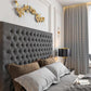 Modern bedroom with tall tufted headboard, pillows, a decorative lamp, and golden wall art. Features a 2025 Florence TV bed.