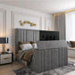 A bedroom with a 2025 lily TV bed, showcasing a gray upholstered headboard and footboard with a concealed TV, elegant décor.