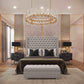 Elegant bedroom with 2025 Nina wingback bed, large tufted headboard, crystal chandelier, and modern black nightstands.
