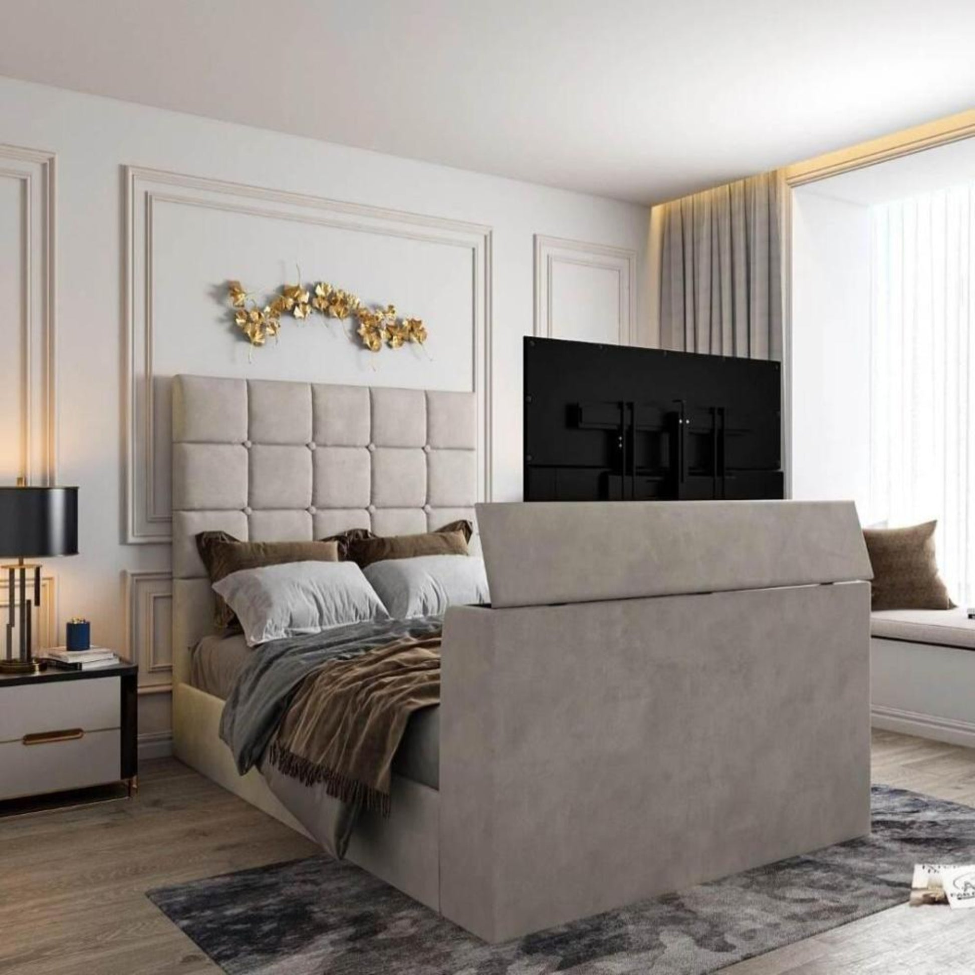 Bedroom with upholstered bed, TV in footboard, 2025 Windsor TV bed, tufted headboard, gold decor, window seat, and light walls.