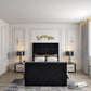 Modern bedroom with a black upholstered bed, 2025 Windsor TV bed, gold wall decor, and elegant lighting on white walls.