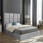 Modern bedroom with a gray upholstered bed and decorative blue pillow.