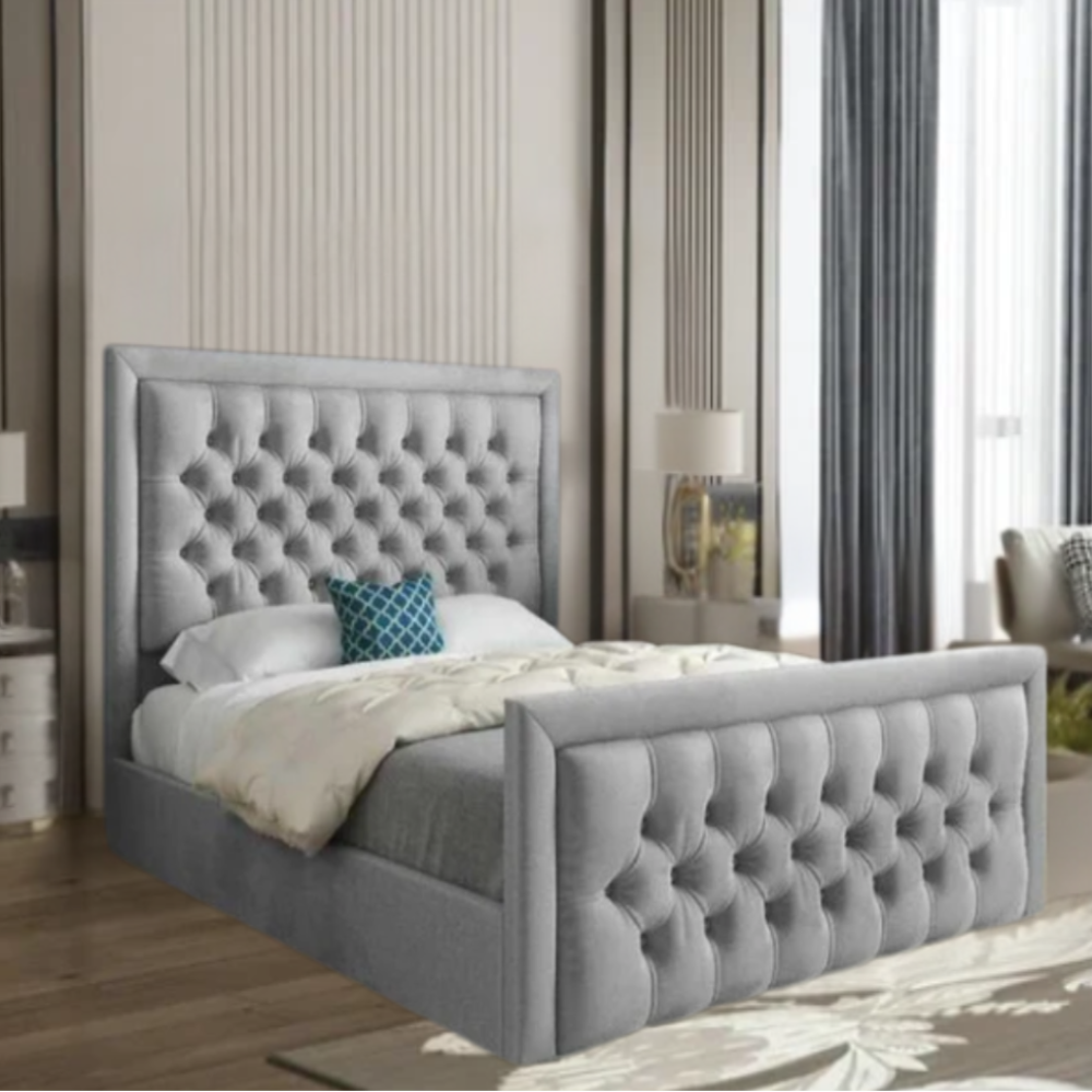 A modern bedroom with a gray upholstered tufted bed, white comforter, and blue decorative pillow.