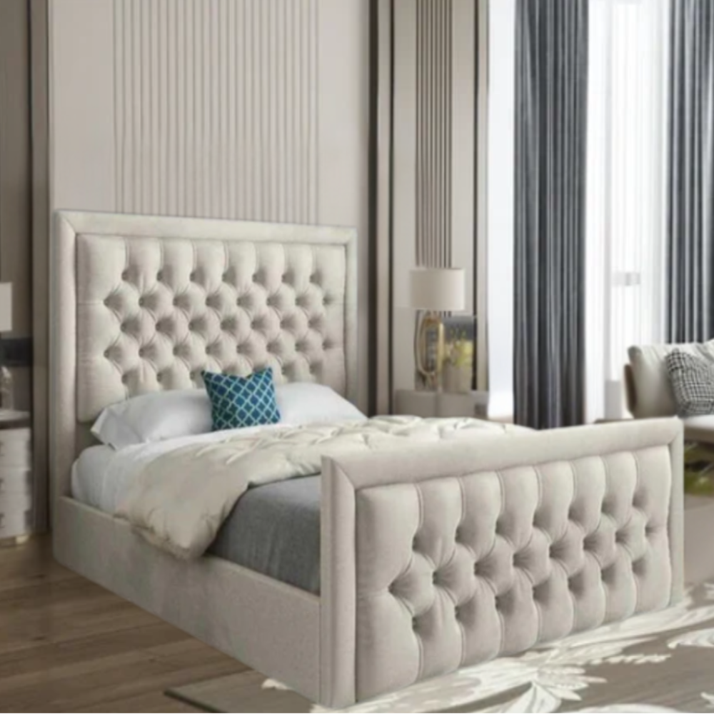 Modern bedroom with a tufted beige bed, blue pillow, lamp on bedside table, and tall drapes.