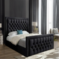 Bedroom with a black tufted bed, white and gray bedding, and a blue pillow.