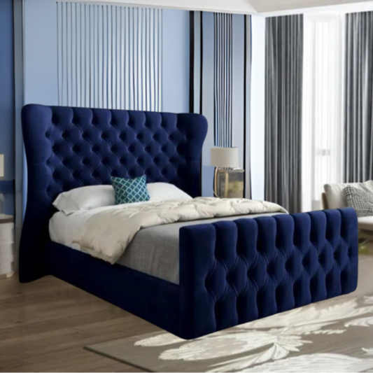 Bedroom with a large blue tufted bed, white and gray bedding, and vertical striped walls.