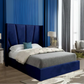 Modern bedroom with a blue upholstered bed and decorative elements.