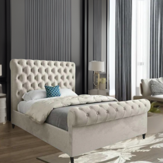 Bedroom interior with a tufted beige bed, dark gray walls, and a blue pillow.