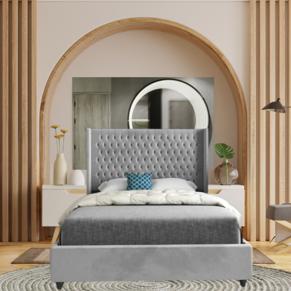 Modern bedroom with a gray upholstered bed, tufted headboard, circular mirror, and wooden arch.